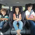 3 niños sentados en autoasiento
